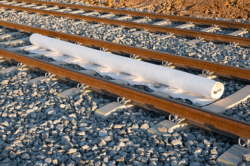 A roll of geotextile is laid on new tracks for the tramway, layer of reinforcement and stability to the newly constructed rail system