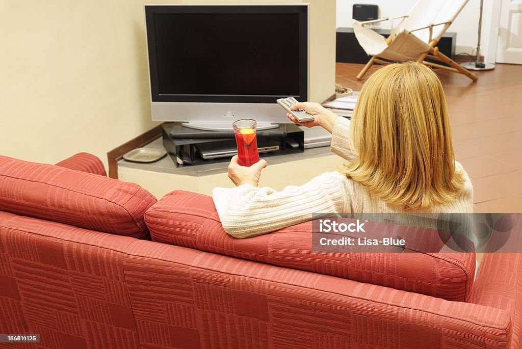 Femme regardant la télévision sur un canapé - Photo de Activité de loisirs libre de droits