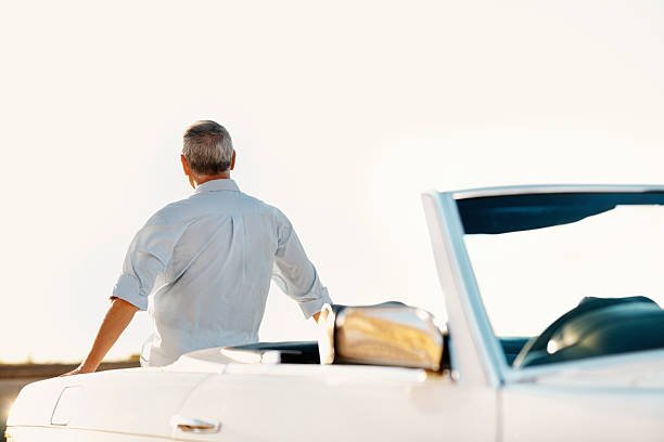 istock Senior man sitting on trunk of car 186814216
