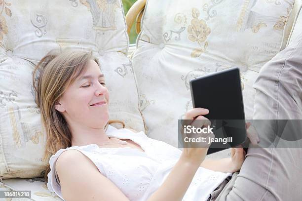 Foto de Mulher Em Um Sofá Com O Tablet Eletrônico e mais fotos de stock de 40-44 anos - 40-44 anos, 40-49 anos, Aconchegante
