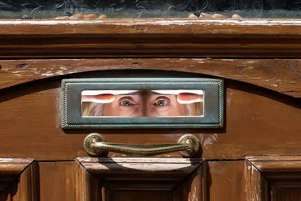 Woman's eyes peering out from letterbox