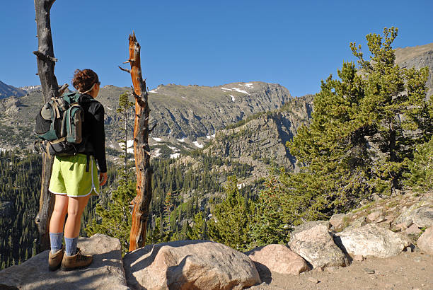 Young Woman Hiking in the Colorado Rockies This young woman is hiking the Flattop Trail in Rocky Mountain National Park near Estes Park, Colorado, USA. jeff goulden rocky mountain national park stock pictures, royalty-free photos & images