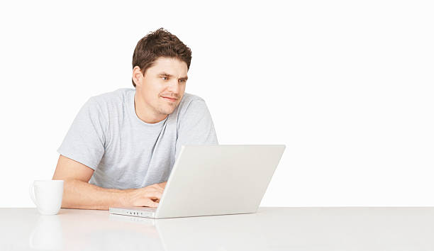 istock Smiling mid adult guy using a laptop over white 186815312