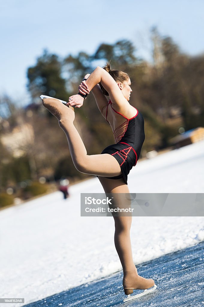 Attractive female ice skating on Bled lake "Side view of attractive female skating on the frozen lake, Bled, Slovenia, Europe" Active Lifestyle Stock Photo