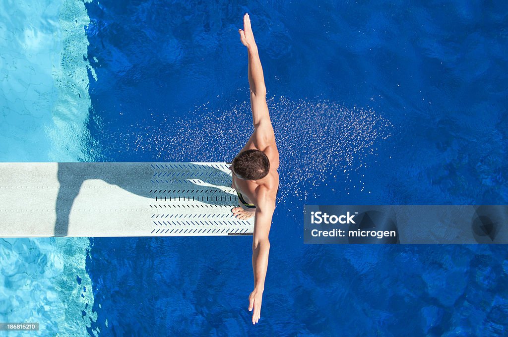 Springboard diving competitor "Springboard diving competitor concentrating before the dive. Shot from above, polarizing filter" Diving Board Stock Photo