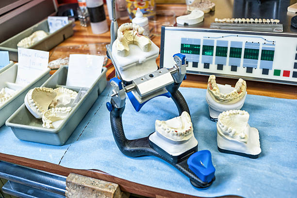 Dentures And Work Tools On A Desk Dentures and work tools on a desk in a dental laboratory. dental drill stock pictures, royalty-free photos & images