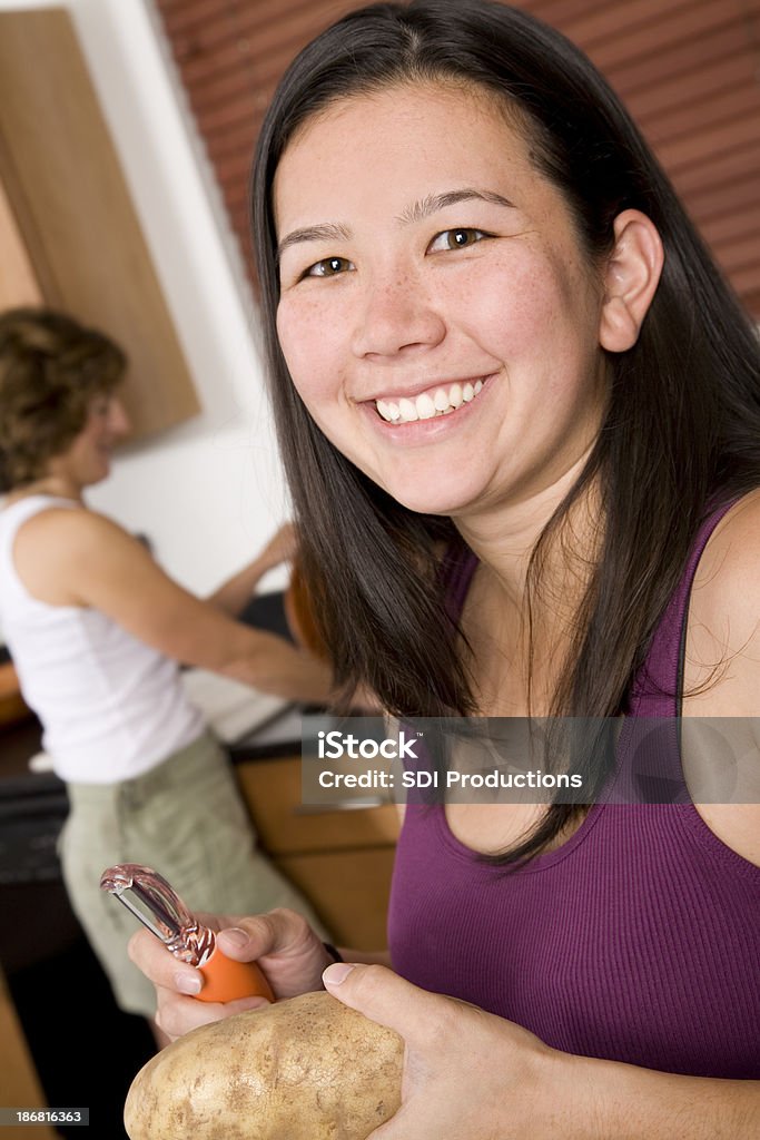 Felice giovane donna preparando la cena nella sua cucina - Foto stock royalty-free di Abilità