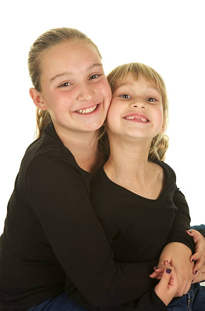 loving irmãs abraçando no fundo branco - embracing smiling gap children only - fotografias e filmes do acervo