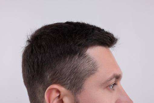 Man with healthy hair on white background, closeup