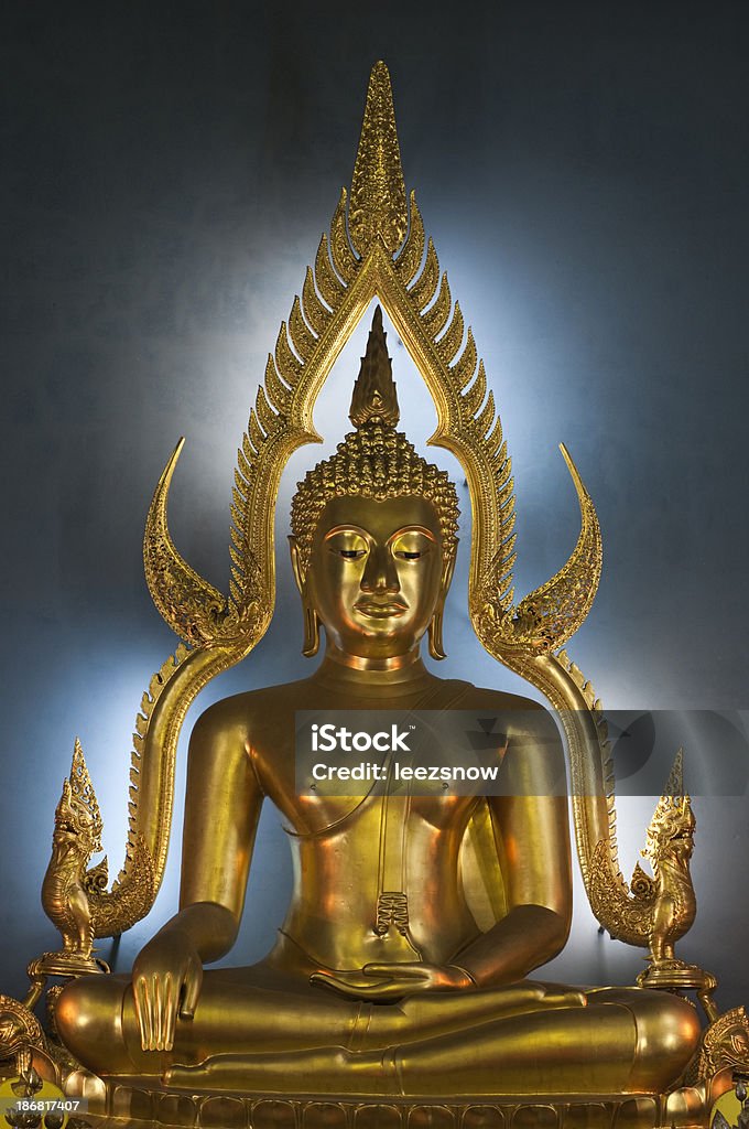 Serene Golden Buddha - Thailand Series Beautifully backlit sitting golden Buddha with blue light background. Taken in a temple in Thailand.See a lightbox of all my shots of Bangkok: Bangkok Stock Photo