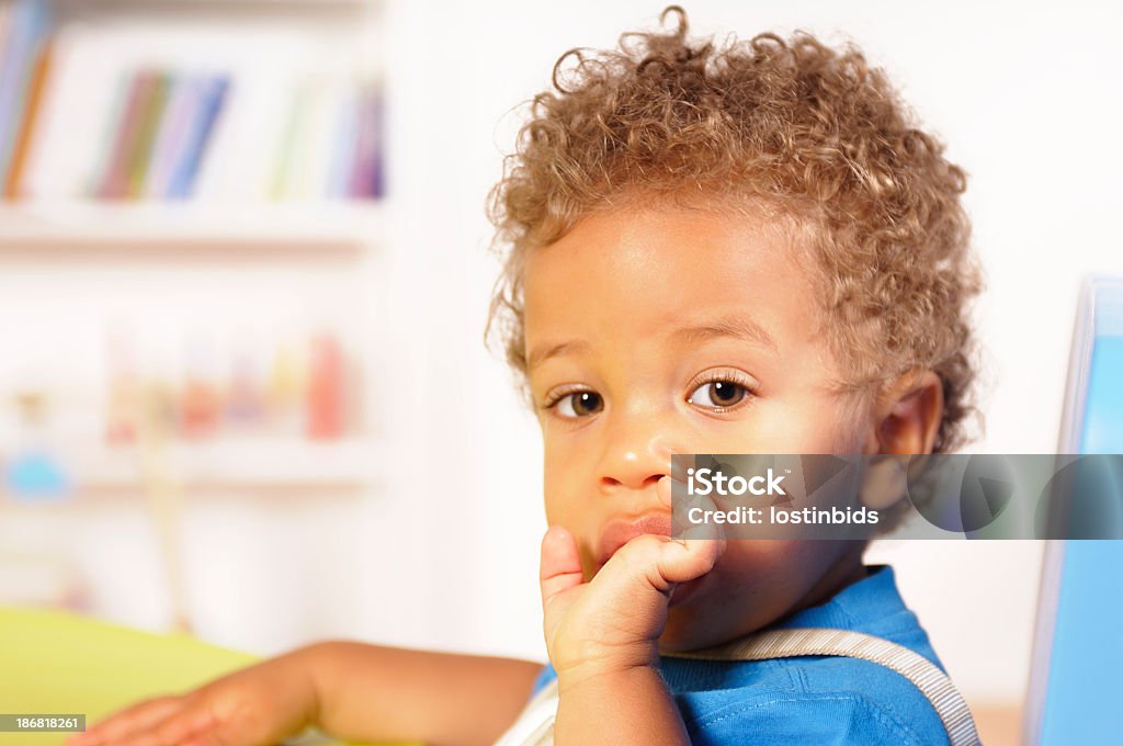 Close-up vista de um bebê/criança pequena Biracial causa seu dedo - Foto de stock de 12-17 meses royalty-free
