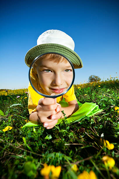 istock Little Boy Looking Through Magnifying Glass 186818404