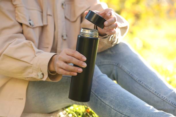 istock Woman opening thermos outdoors on sunny day, closeup 1868185335