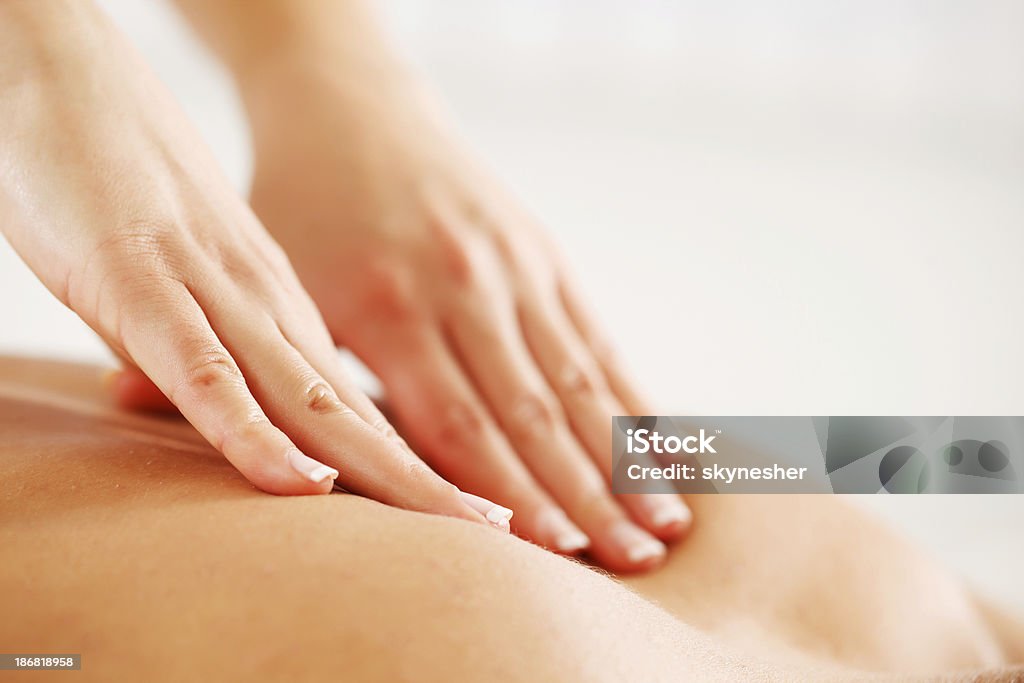 Hands giving back massage Close-up of a back massage.  White background. Massaging Stock Photo