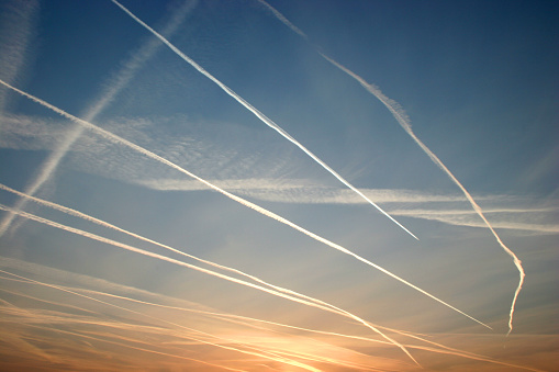 an early morning shot of vapour trails in a crisp blue sky