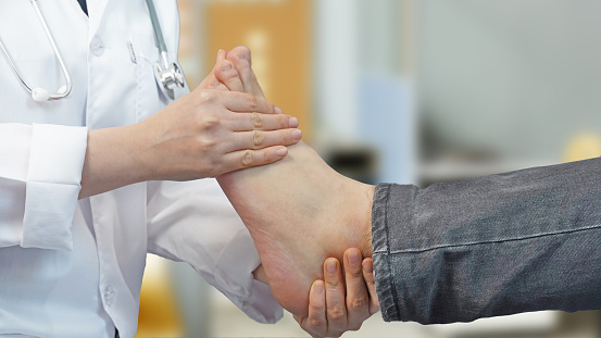 Doctor is checking patient's leg after operation.