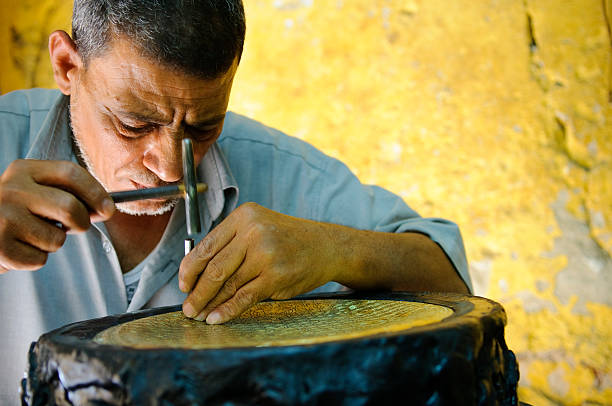 istock Egyptian metal worker doing his craft 186820498