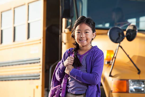 istock Girl in front of school bus 186820701