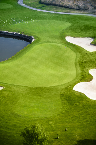 Fairway and sand traps of a green golf course from a bird eye view