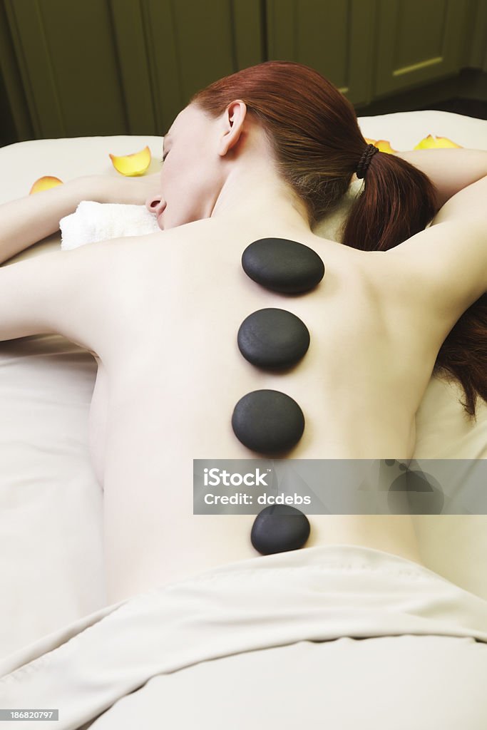 Woman Relaxing at the Spa A beautiful red haired woman relaxing at the spa with a hot stone massage. 20-29 Years Stock Photo