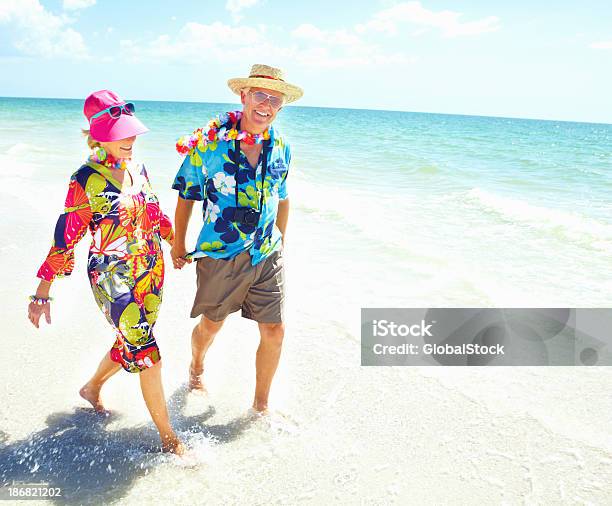 Pensione Coppia Holding Mani Lungo La Spiaggia - Fotografie stock e altre immagini di 60-69 anni - 60-69 anni, Abbigliamento casual, Adulto