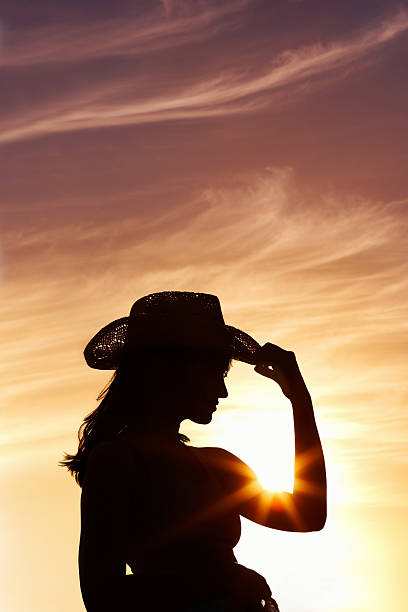 istock Woman wearing a straw hat against beautiful sunset 186821436
