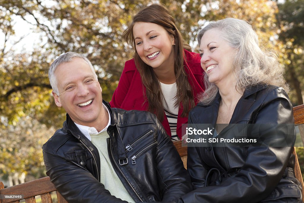 Padre sonriente con su hija en el parque - Foto de stock de Abrazar libre de derechos