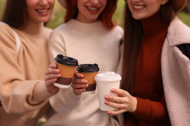 istock Happy three friends with cups of coffee outdoors, closeup 1868216802