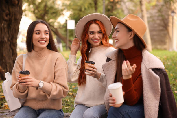 istock Happy friends talking and enjoying coffee in park 1868217559
