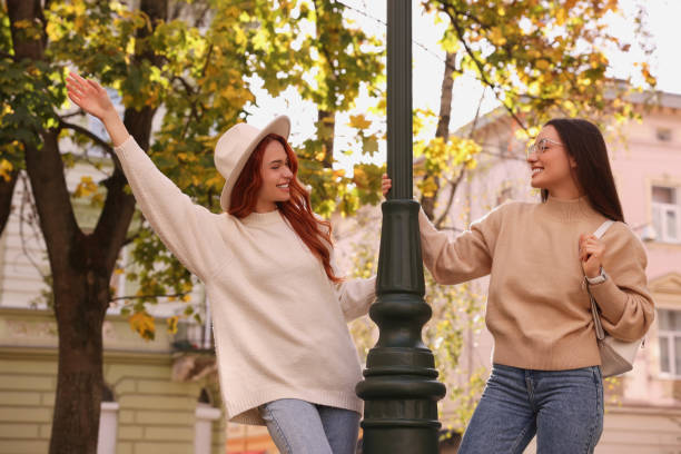 Happy friends having fun outdoors on autumn day