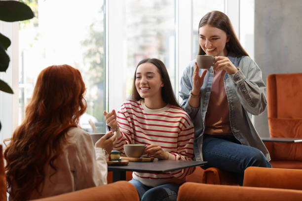 istock Happy friends talking and drinking coffee in cafe 1868224349