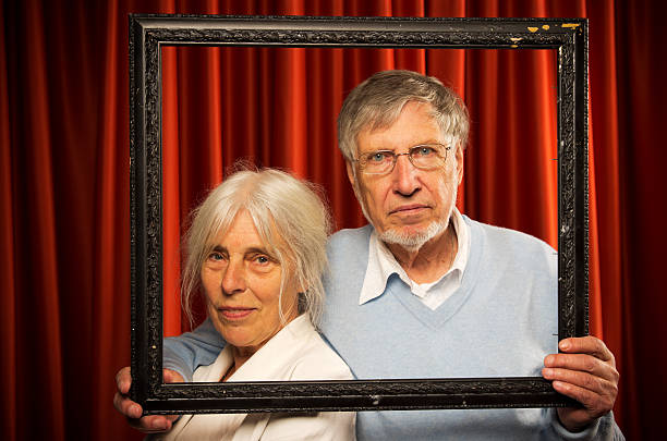 istock Senior couple holding picture frame 186823282