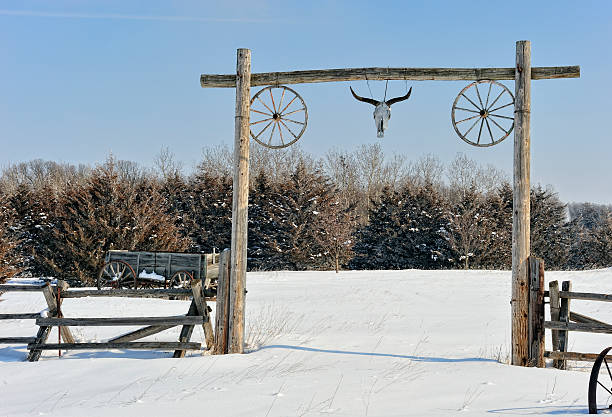 Rustic western scene Old west style fence and entrance in winter scene covered wagon horse cart snow winter stock pictures, royalty-free photos & images