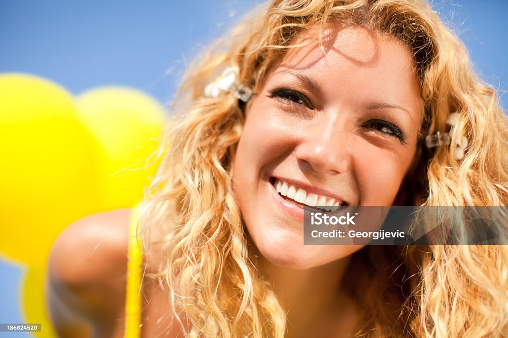 Freedom Woman in yellow dress having fun with yellow balloons in nature. Activity Stock Photo