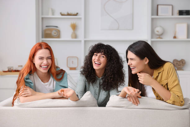 istock Happy young friends having fun together on sofa at home 1868246311