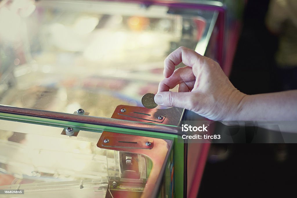 Caucasien femme mettant pièce de machine à sous - Photo de Jeux d'arcade libre de droits