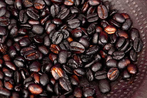 Close up image of Ethiopian roasted coffee grains on clay saucer.