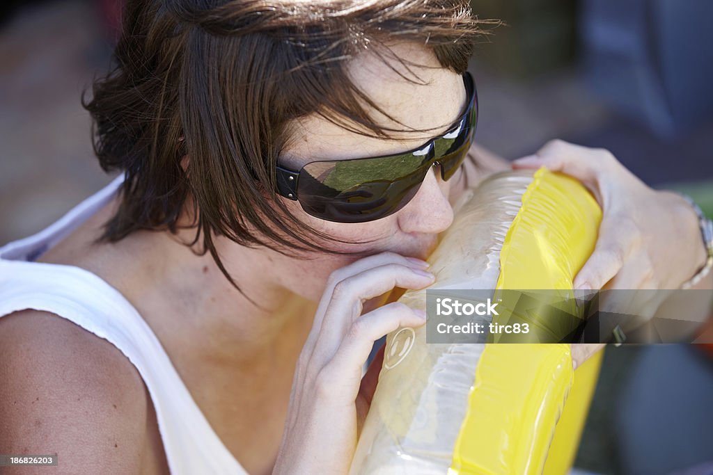 Femme à lunettes de soleil gonfler un anneau en caoutchouc - Photo de Adulte libre de droits
