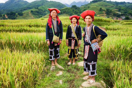 Red Dao women usually wear a long blouse over trousers and traditional red hat.