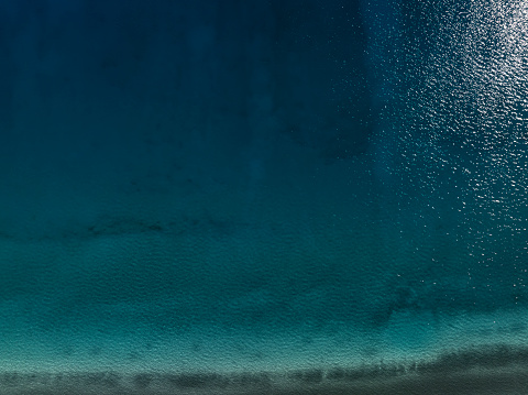 Background image of Soft wave of blue ocean on sandy beach.  Ocean wave close up with copy space for text\