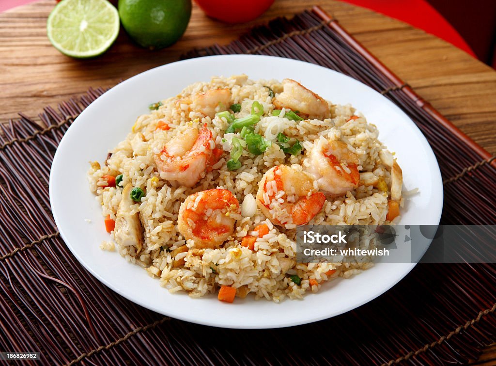 Plate of shrimp fried rice on a placemat and wood table Shrimp & Chicken Fried Rice Fried Rice Stock Photo