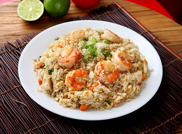 Plate of shrimp fried rice on a placemat and wood table Shrimp & Chicken Fried Rice fried photos stock pictures, royalty-free photos & images