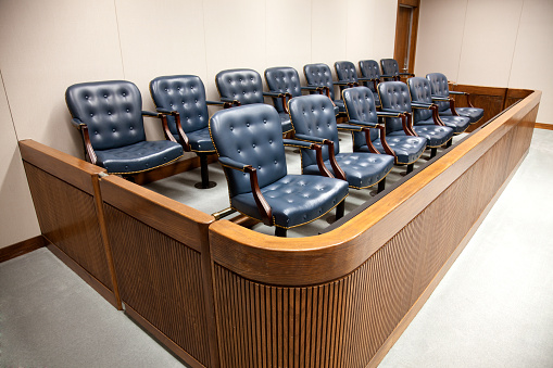 A united states federal courtroom jury box of 14 jury seats.
