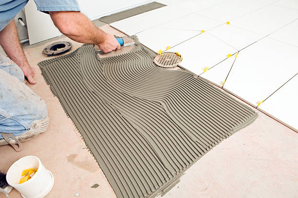 istock Tile Setter Troweling Mortar on a Concrete Floor 186827756