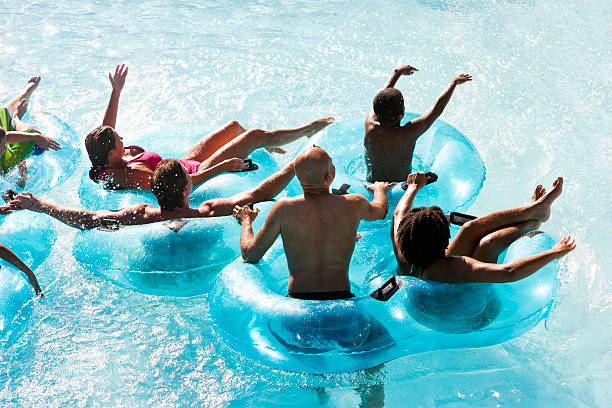 группа людей на innertubes в воде парк - water park inflatable ring water swimming pool стоковые фото и изображения