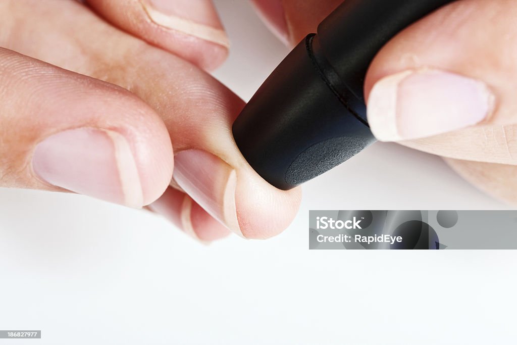 Primo piano delle mani con automatico lancet per il prelievo del sangue - Foto stock royalty-free di Apparecchiatura medica