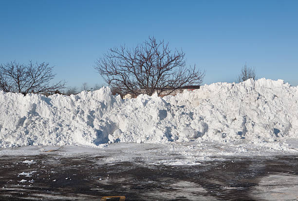 огромная snowpiles в plowed парковка - thick snow стоковые фото и изображения