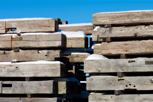 A pile of hand hewn barn beams read to be recycled into exotic timber. (Stacked outside as evident by snow.)Related Images: