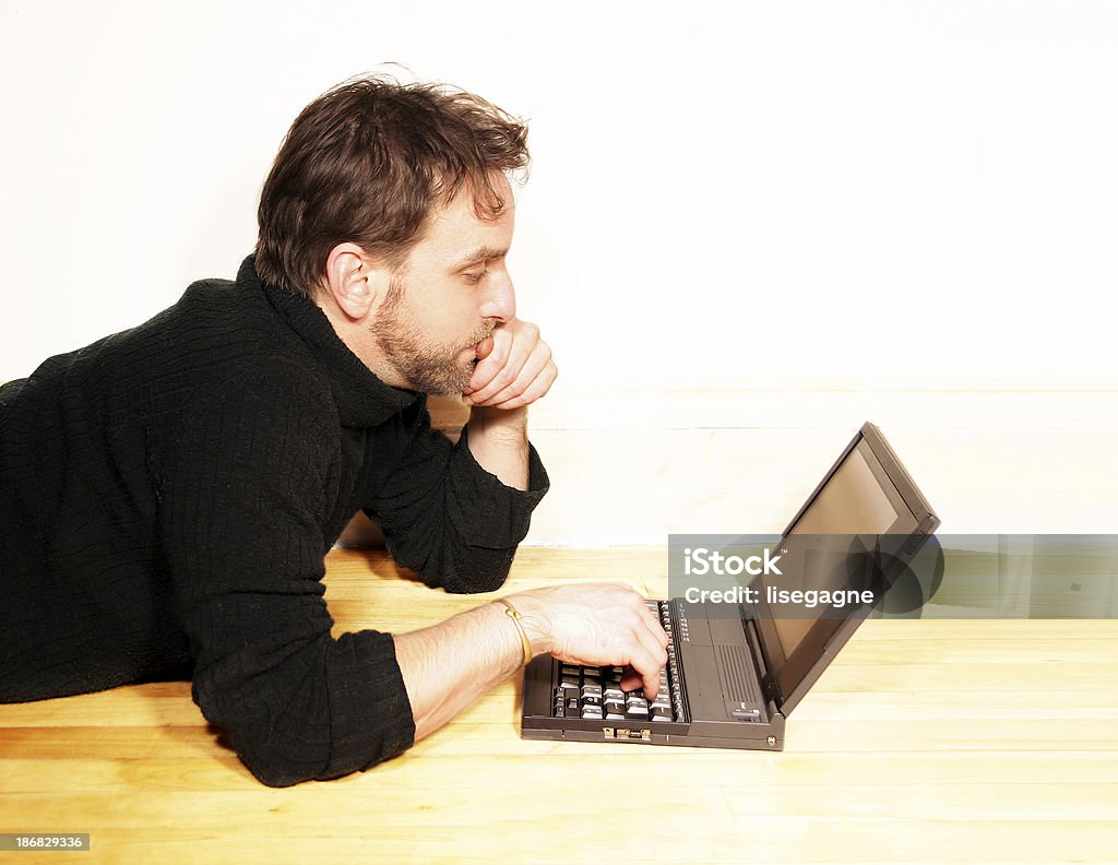 Rilassata uomo che lavora sul suo computer portatile - Foto stock royalty-free di Colore nero