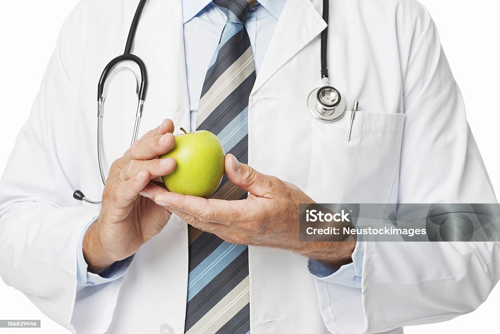 Midsection of Doctor Holding Green Apple - Isolated Midsection of male doctor holding fresh green apple. Horizontal shot. Isolated on white. 30-39 Years Stock Photo